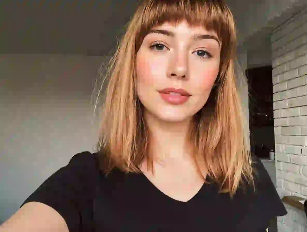 Enhanced selfie of a blonde girl with flawless skin and plump, rosy lips.