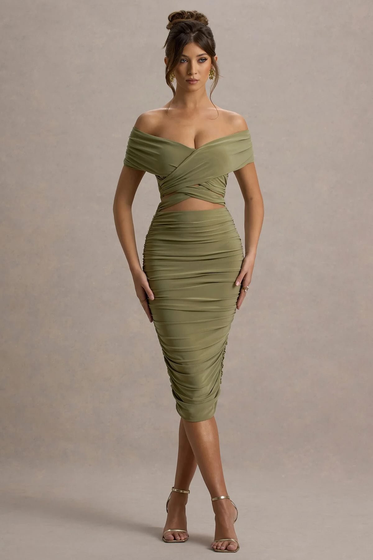 A full-body shot of a clothing swap hot chick, dressed in a green wrap dress, showing how to change clothing.